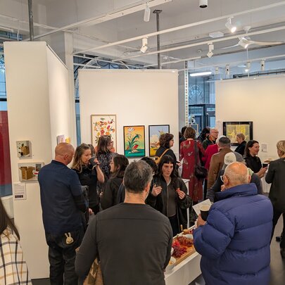 People in a a gallery space, mingling.