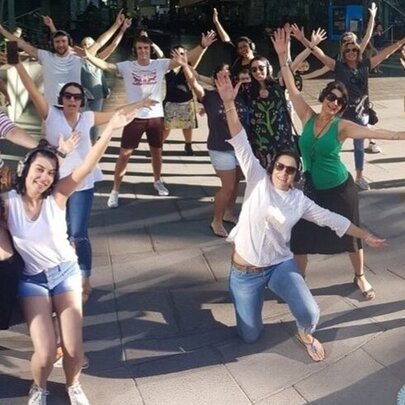 Tour participants posing with arms and legs oustretched in a public space.