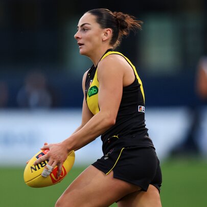 Richmond footballer Monique Conti runs with the ball in her hands. 