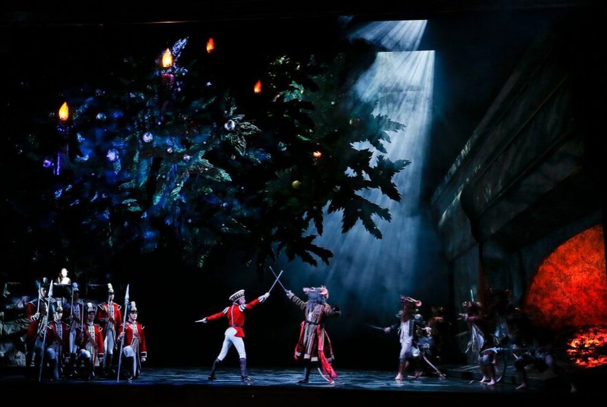 Performers on stage fighting with swords in a production of The Nutcracker. 