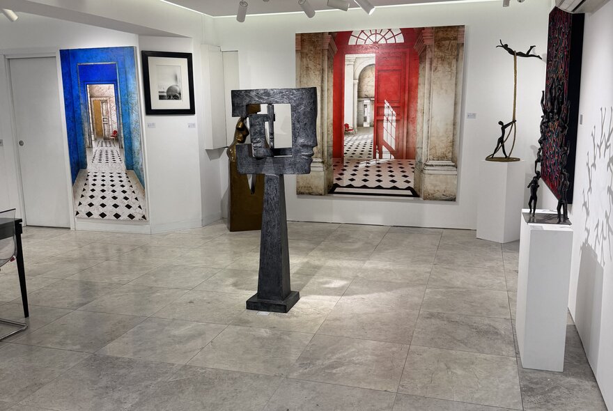 A display of hanging and standing artwork in a gallery setting.