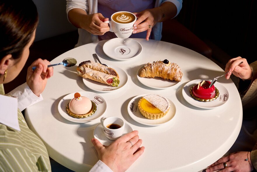 Looking down on a table with three people having coffee and cakes at Brunetti Classico. 