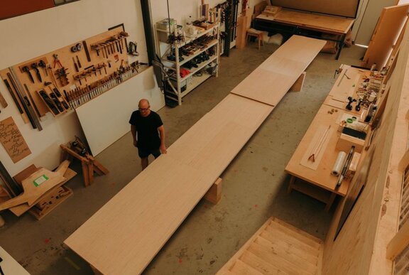 A designer in a furniture workshop, showing the creation of large timber furniture.