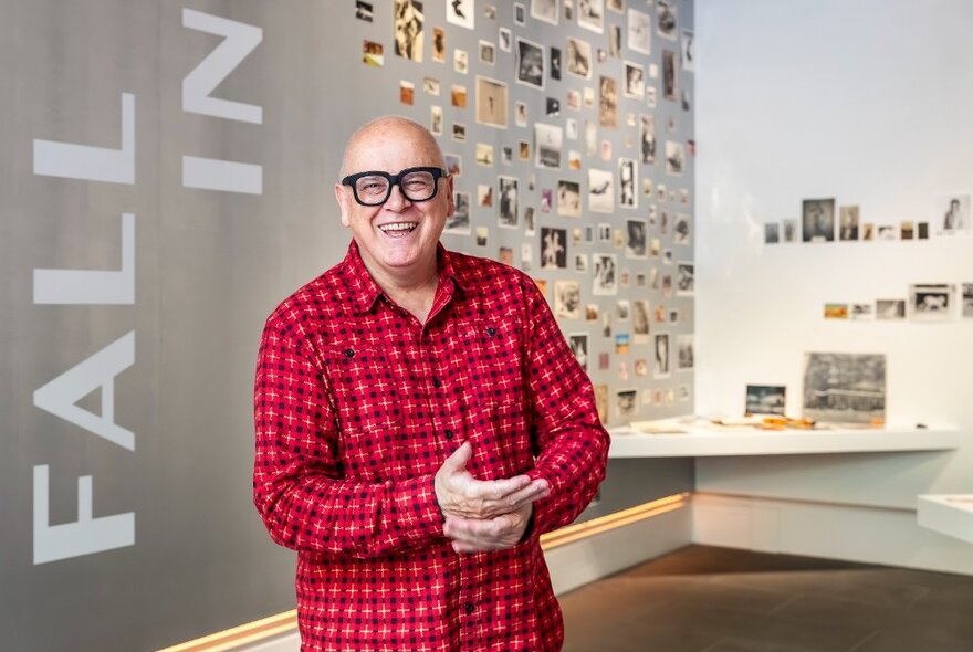 Smiling artist Patrick Pound standing in front of his art exhibition on display at City Gallery.