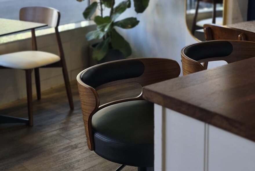 Leather and woodgrain bar stools at a bench in a cafe.