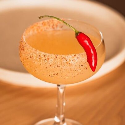 A spicy margarita cocktail with a red chilli garnish.