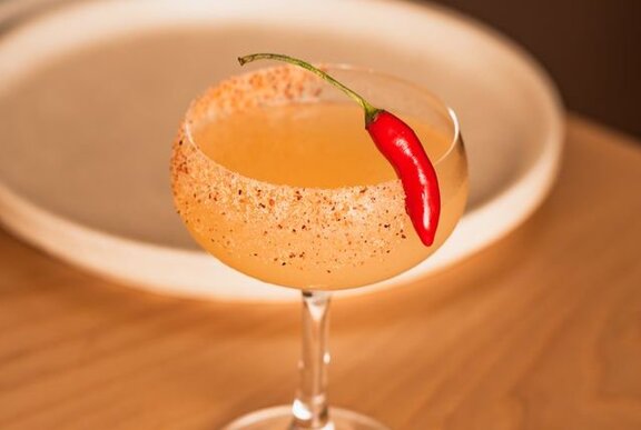 A spicy margarita cocktail with a red chilli garnish.