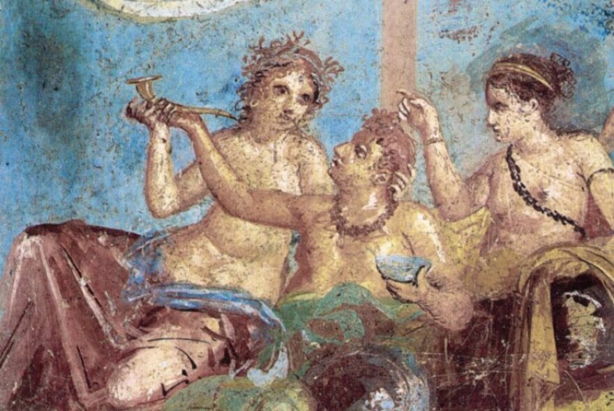 An ancient Roman fresco or wall mural depicting semi-naked people reclining around a banquet table, eating and drinking.