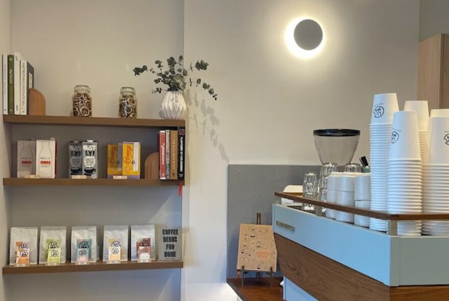 Interior of Luna Cafe, with a coffee machine and shelves displaying bags of coffee for sale.