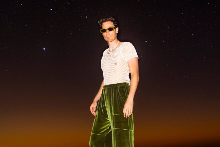 DJ Harvey Miller wearing plush green velvet trousers, a white t-shirt and dark glasses.