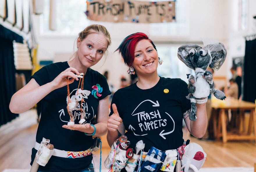 Two people from the professional puppetier company, Trash Puppets, holding puppets created entirely from rubbish.