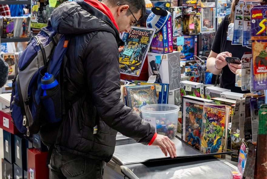 Person looking at displays on a market stall at a toy collectors fair.