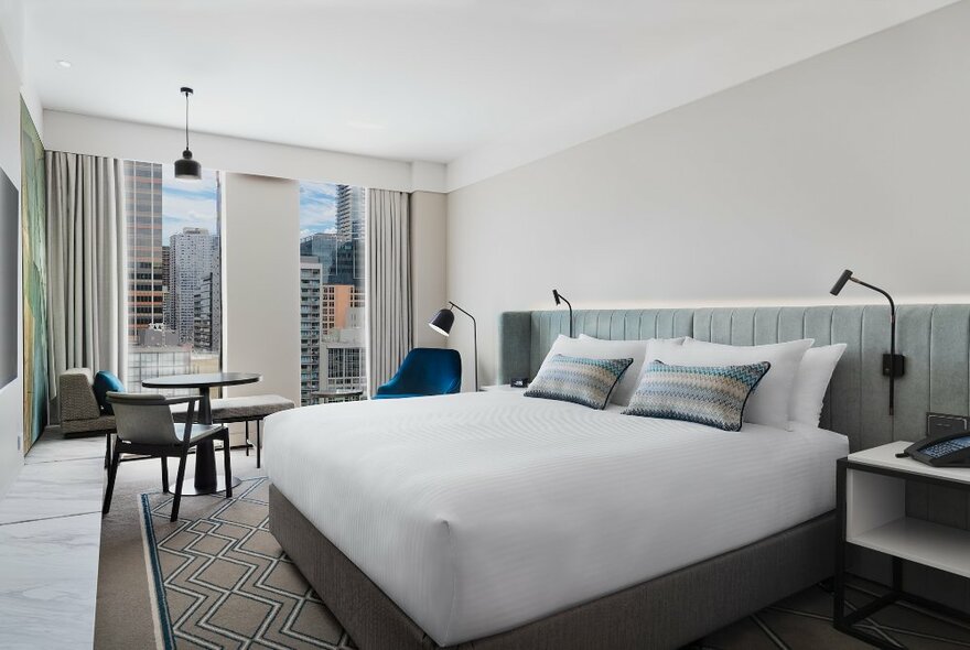 A hotel bedroom with a city view. 