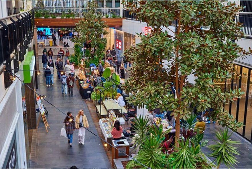 View looking down on people browsing market stalls.