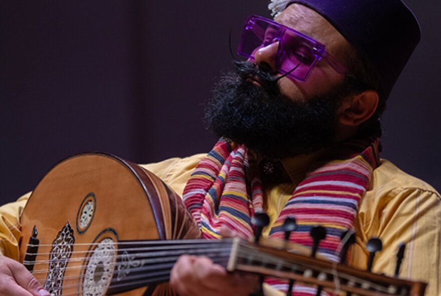 Joseph Tawadros looking reflective while playing an oud.