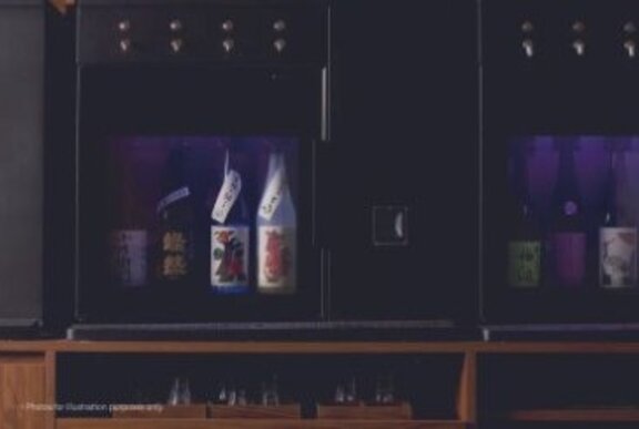 A sake dispenser with bottles in a glass fronted cabinet and automatic taps.