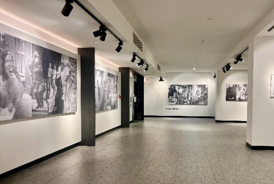 Gallery walls hung with large black and white artworks.