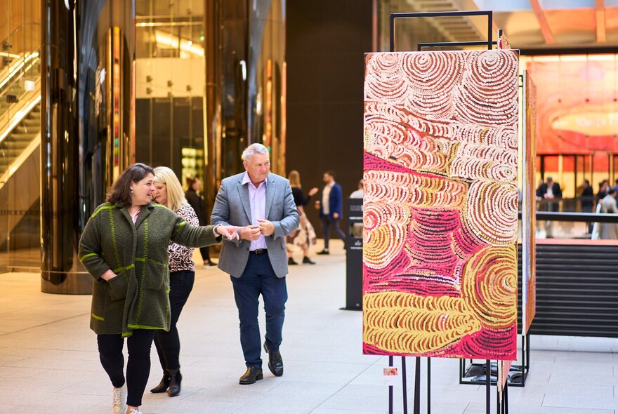 A foyer with First Nations artwork on show as people walk by.