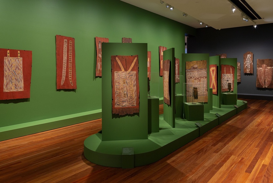 A gallery space inside the Potter Museum of Art, with Indigenous artworks showcased against green walls.