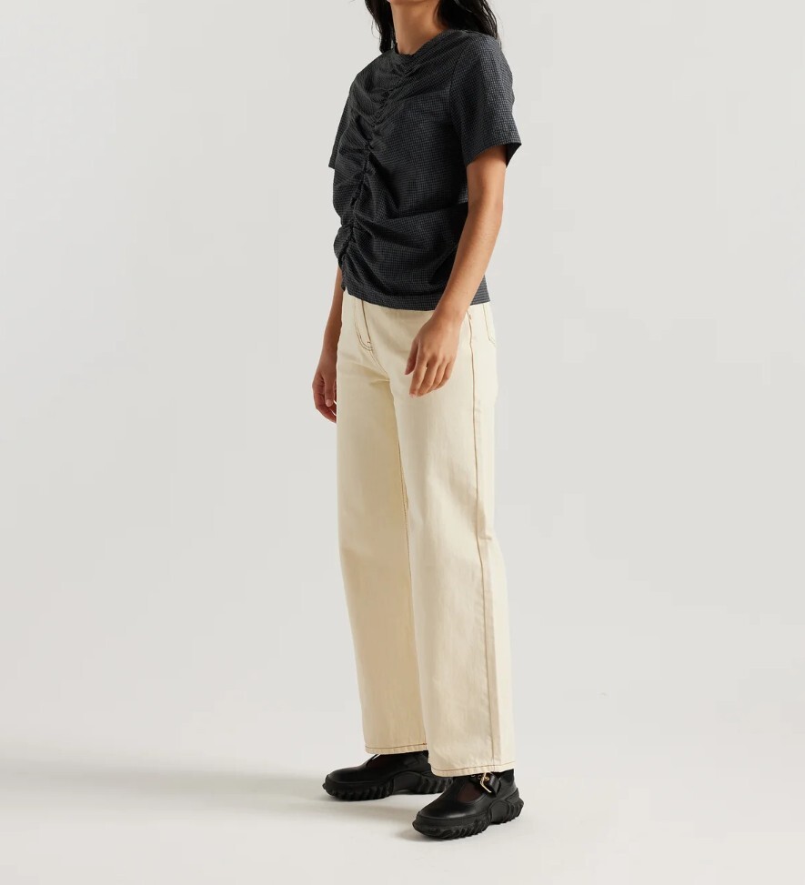A person is wearing a pair of cream jeans