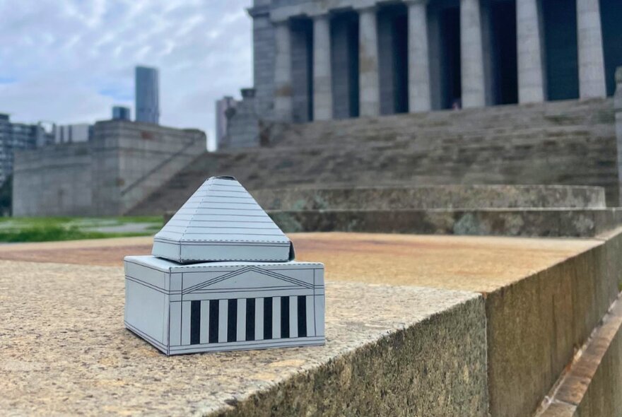 A cardboard model of the Shrine of Remembrance on a plinth near the steps leading to the Shrine.