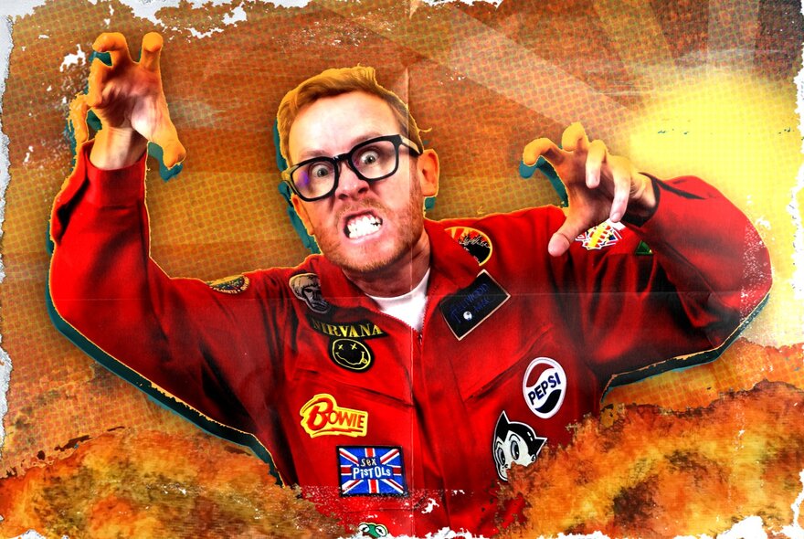 A man in a red racing suit with patches sewn all over it, holding his arms and hands up in a godzilla pose.