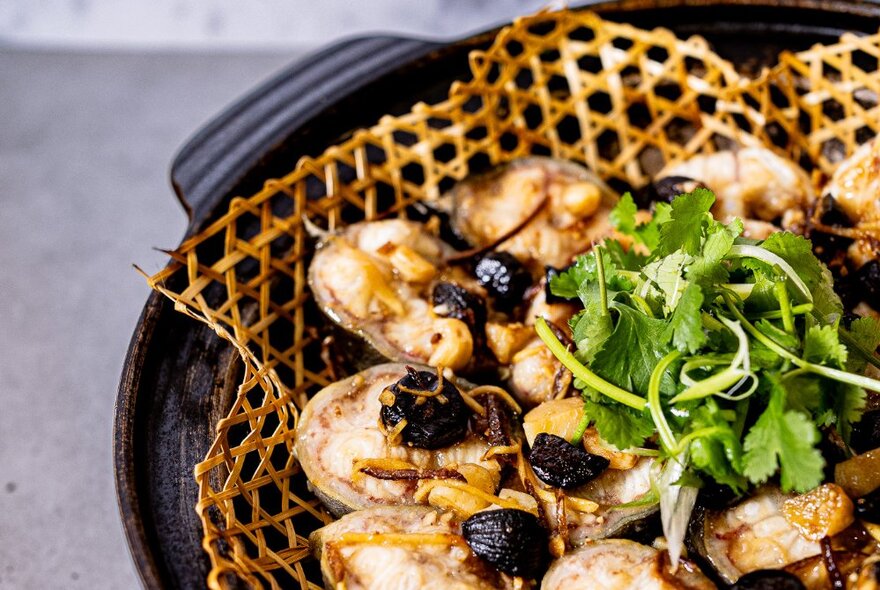 A plate of food on a table, garnished with fresh coriander.