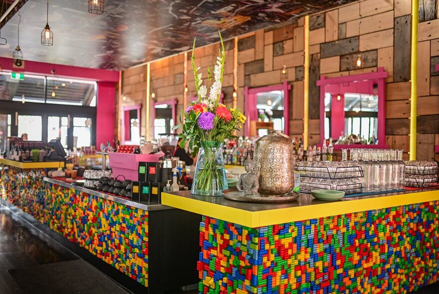 A colourful mosaic restaurant counter with a water cooler and glasses