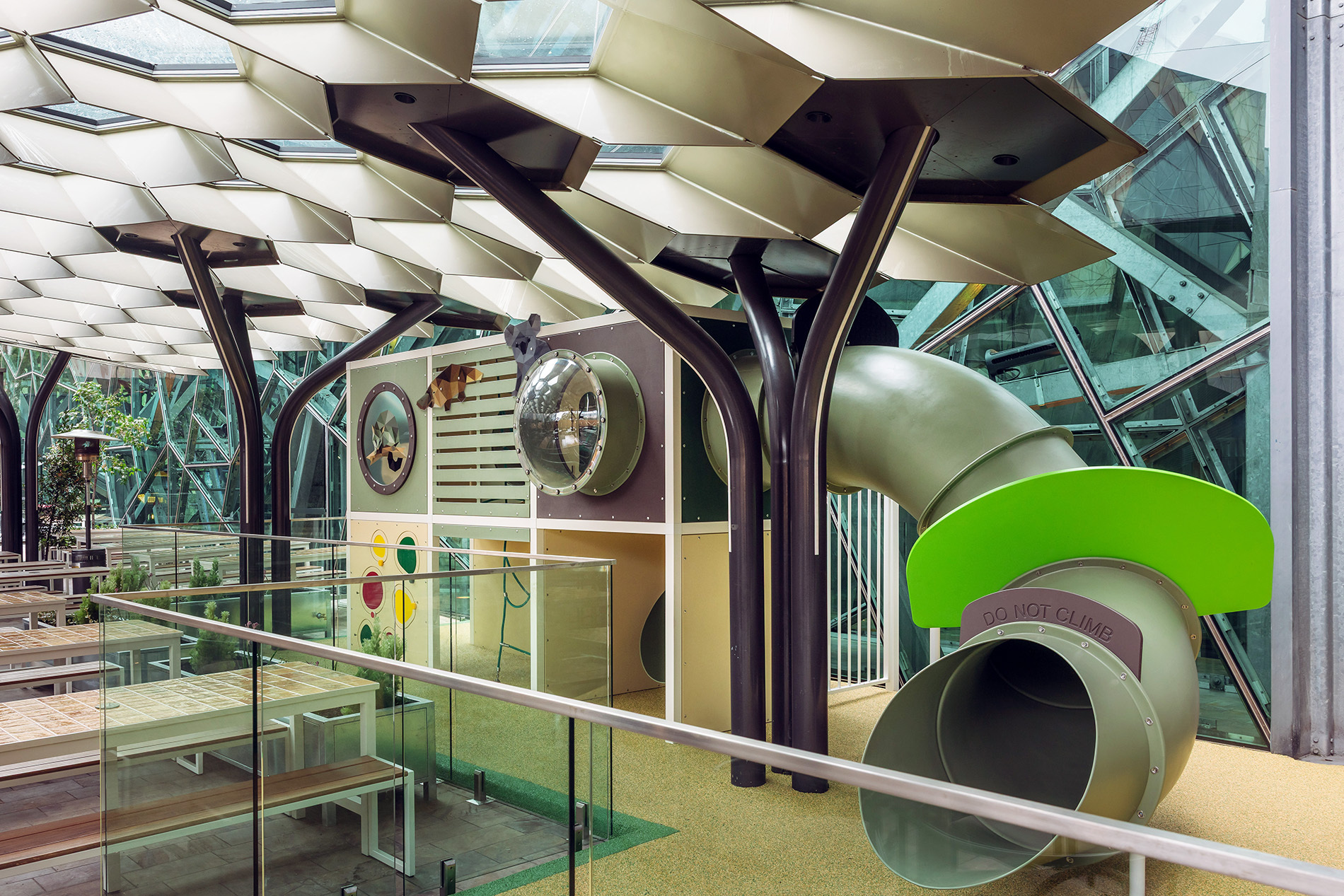 A kids playground with a slide inside a restaurant.