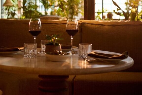 Drinks on a restaurant table backlit by windows.