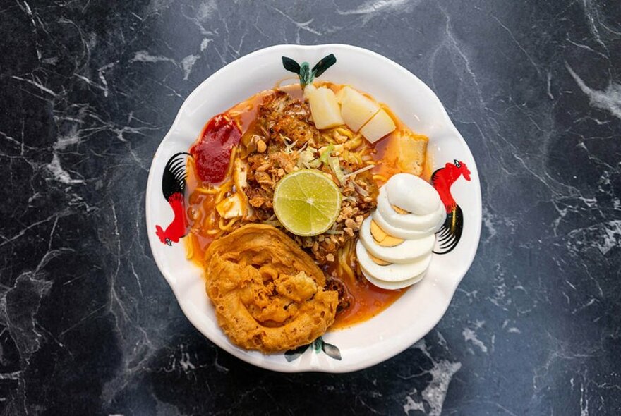 Bowl of fried Asian food wish sliced hard boiled egg.