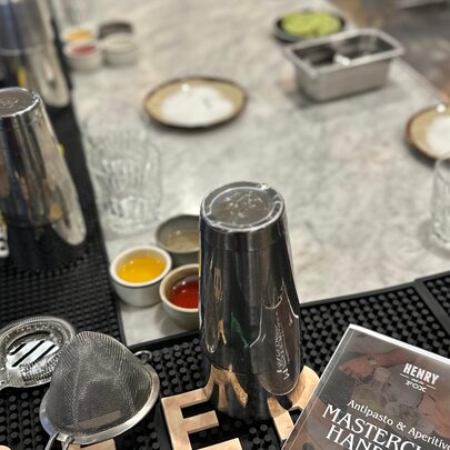 A collection of cocktail tools, including a shaker, strainer and glassware.