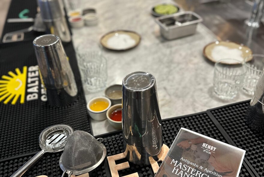 A collection of cocktail tools, including a shaker, strainer and glassware.