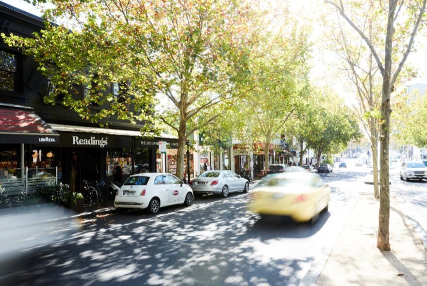 Readings bookstore in leafy Lygon Street with cars whizzing past.
