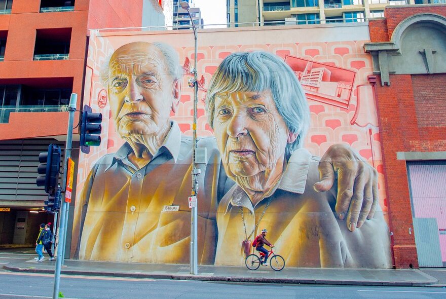 A street art painting of two elderly people