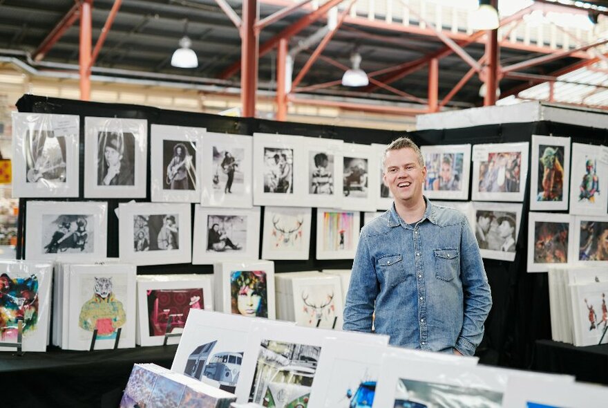 A man surrounding by art prints.