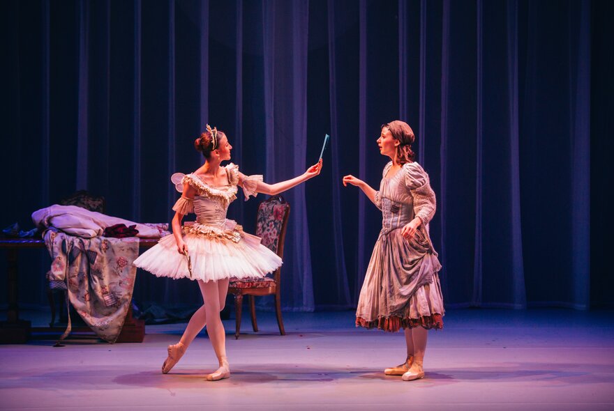 Two ballerinas on stage, one dressed in Cinderella's rags and the other in a fairy outfit.