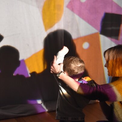 An interactive shadow-play and creative session at ArtPlay with a child and an adult participating.