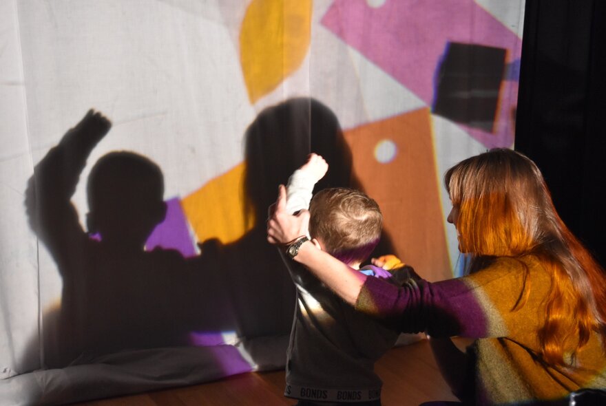 An interactive shadow-play and creative session at ArtPlay with a child and an adult participating.