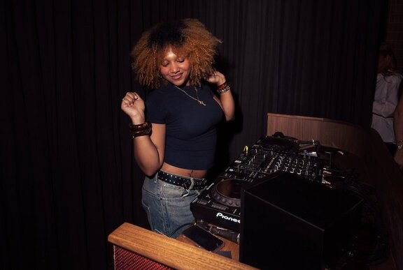 A DJ dancing in the booth.