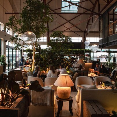 A restaurant with warm lighting and lots of greenery.