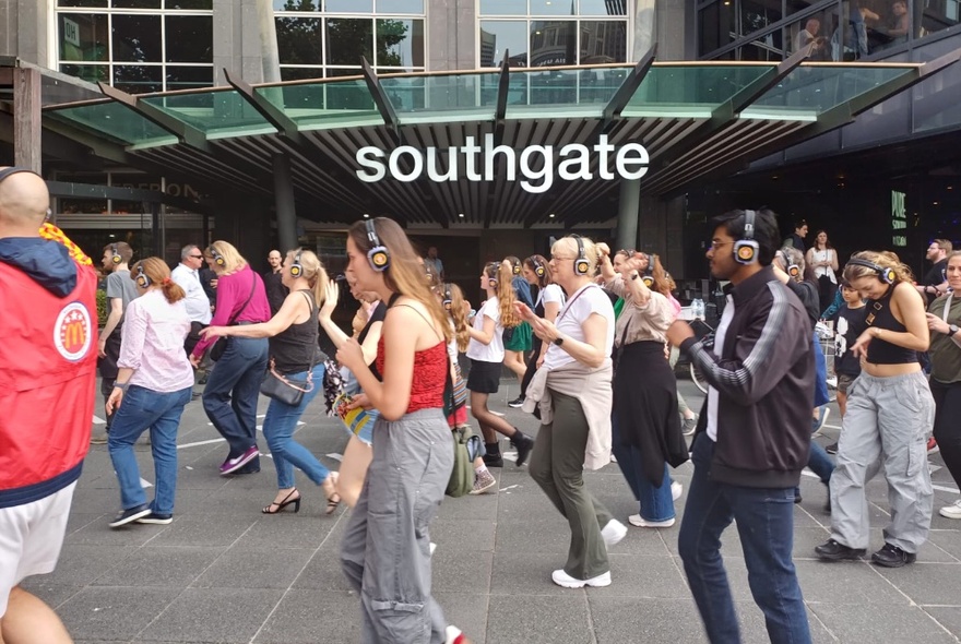 Group of disco walking tour participants dancing outside the shopping mall at Southgate.