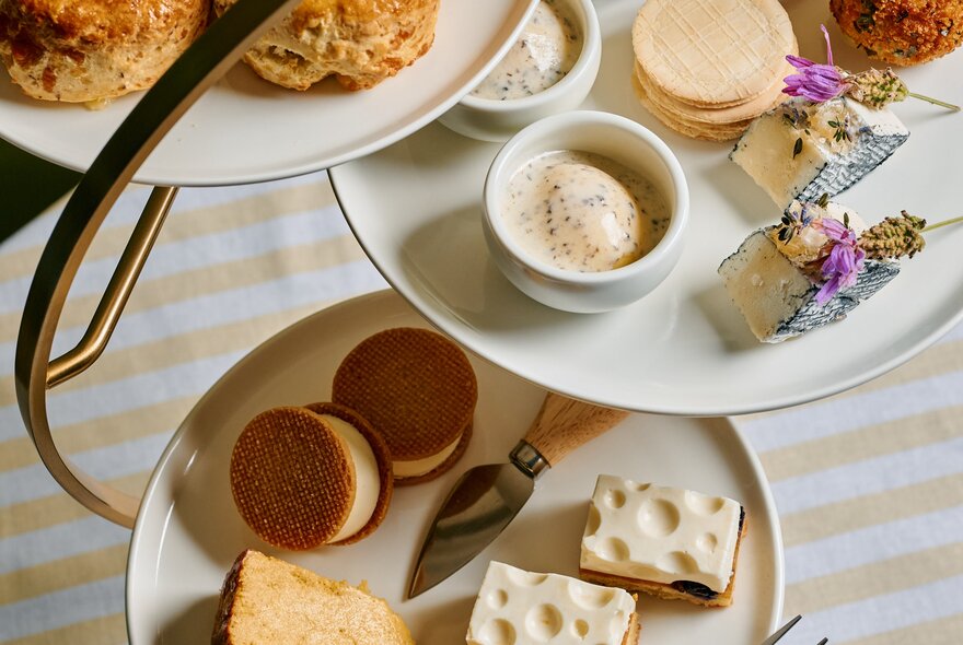 A three-tiered cake stand displaying a variety of sweet and savoury cheese treats, seen from above.