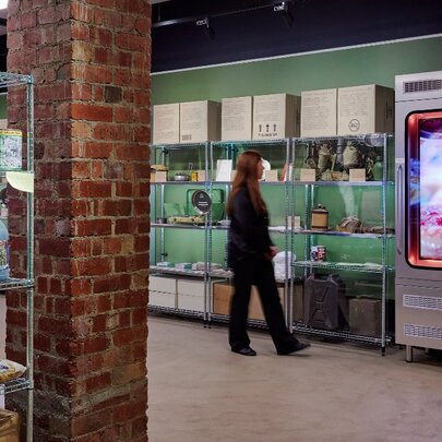 A woman walking through a display with shelves of military-style food packages.