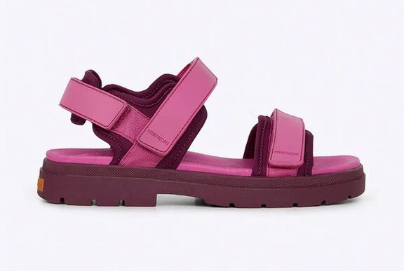 Side view of a bright pink flat sandal against a white background.