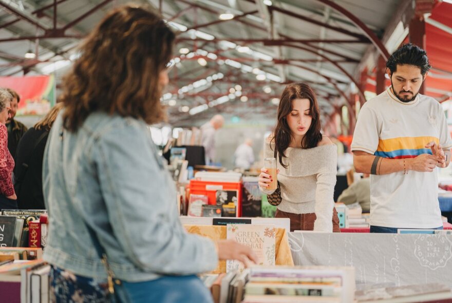 People browsing a stall in one of the large sheds at the Queen Victoria Market.