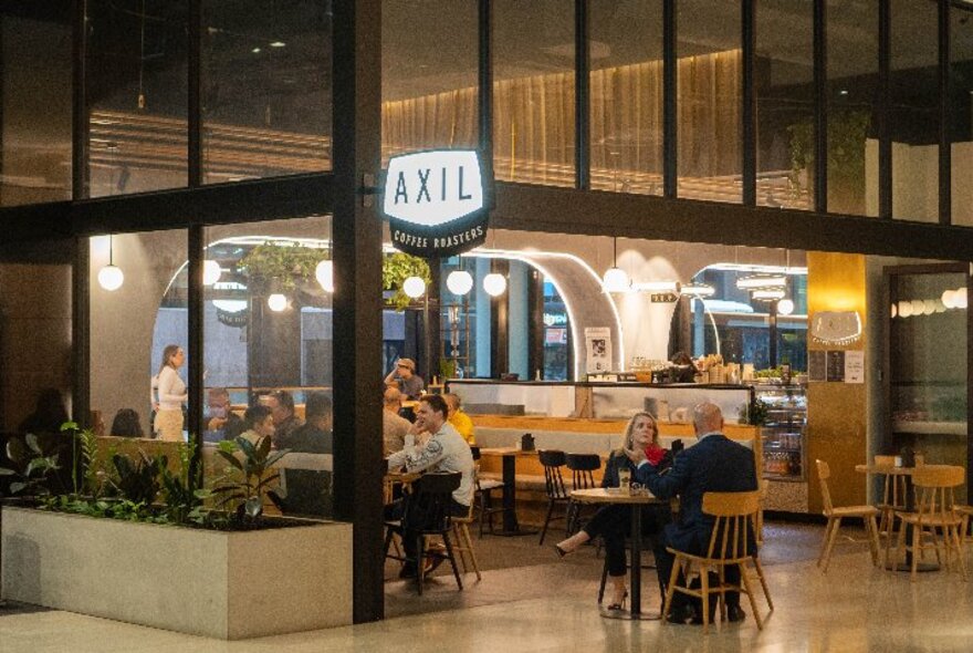 View looking into Axil Coffee at Bourke Street, with people seated at tables in the lobby.