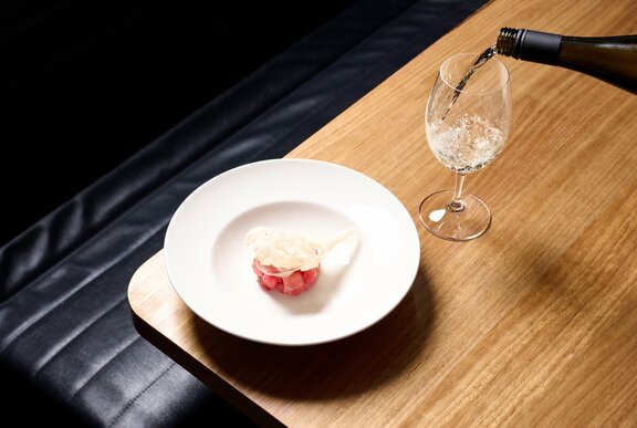 A dessert with a glass of white wine being poured.