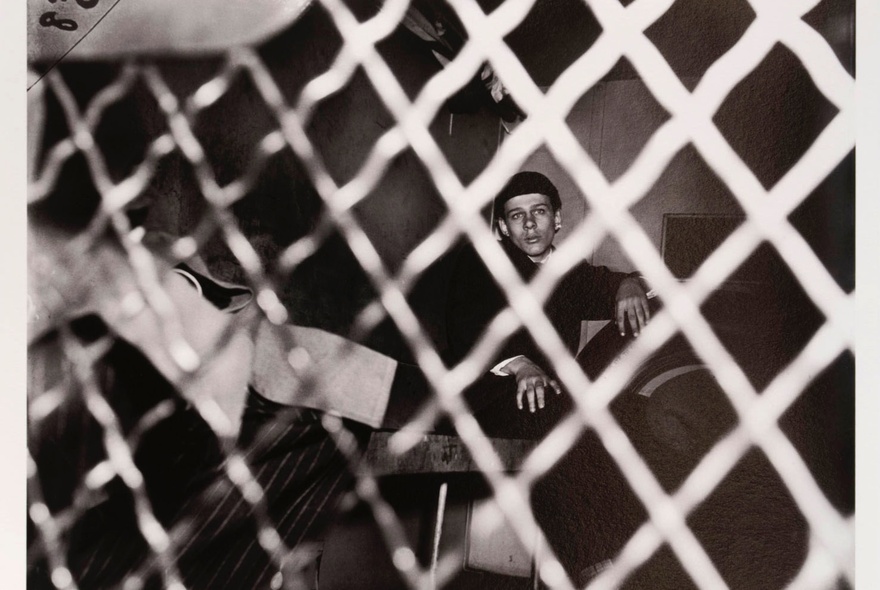 Art photo of a person behind a wire fence.