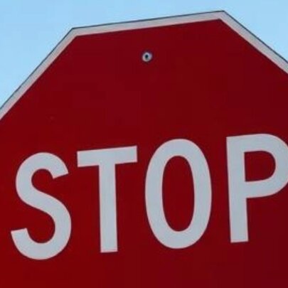 A stop sign with the bottom segment sliced off. 